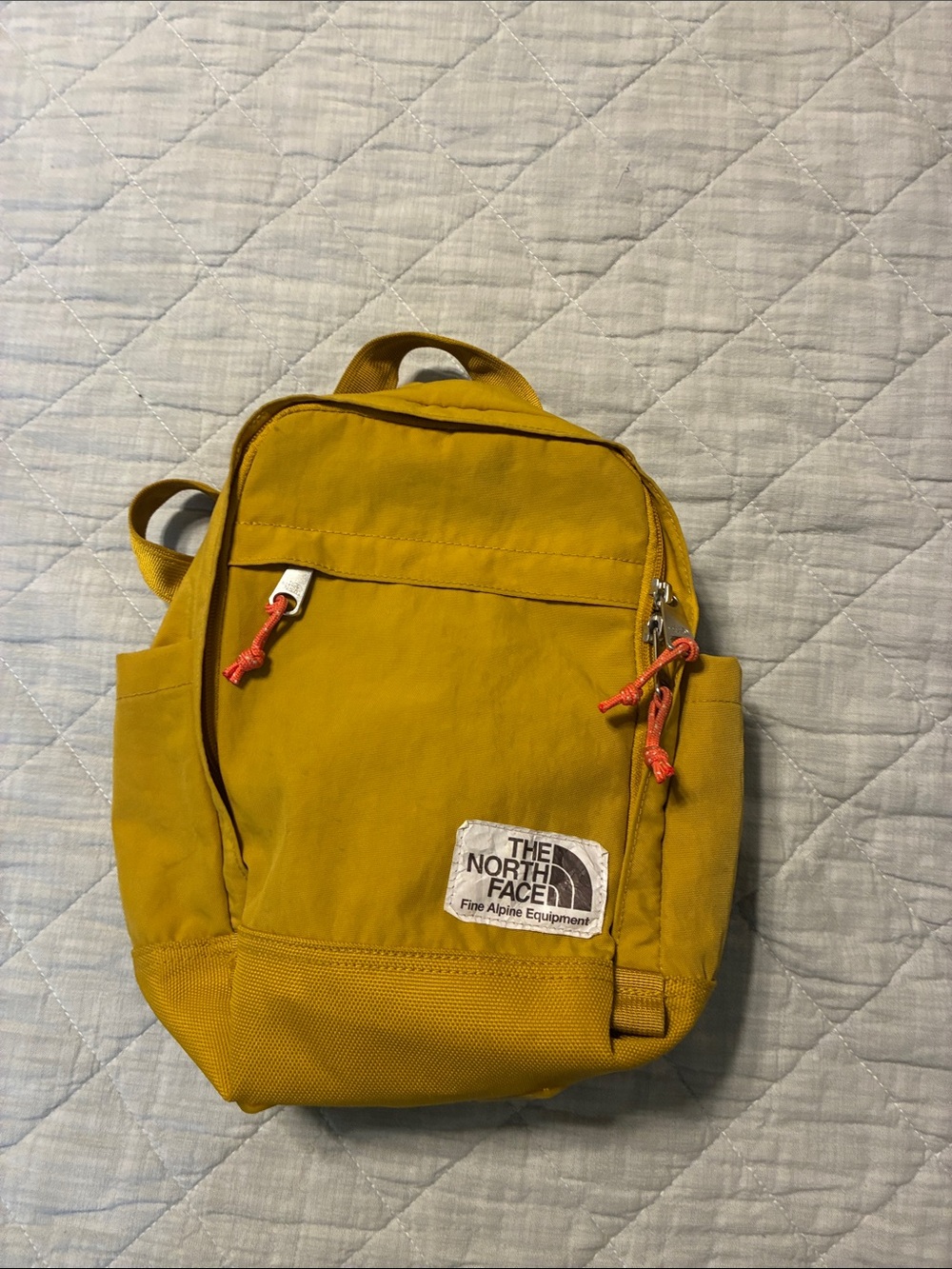 The North Face Mustard Yellow Mini Daypack with Orange Accent Pulls